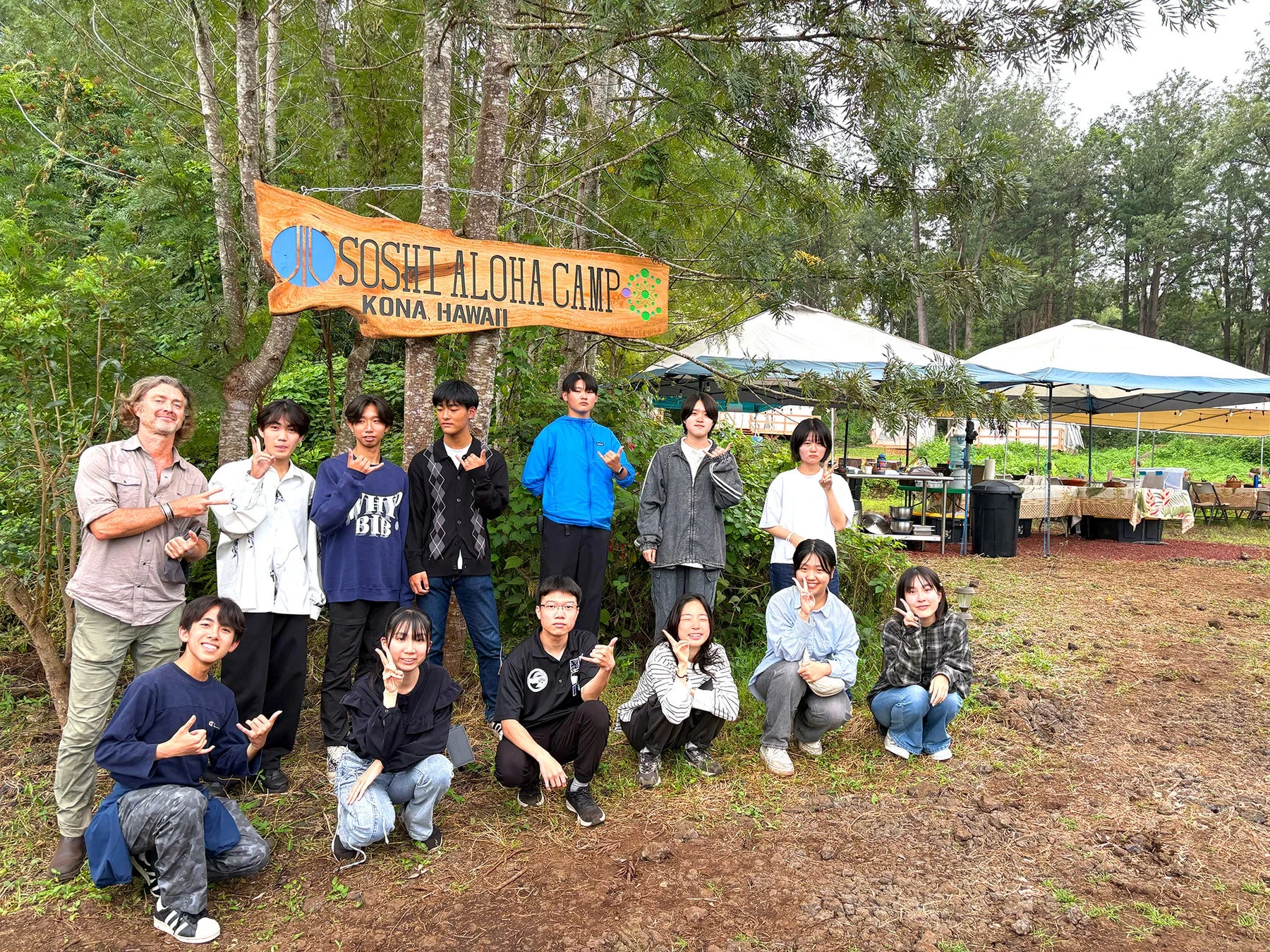 「SOSHI ALOHA CAMP KONA HAWAII」の看板の下での集合写真